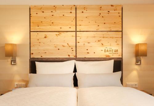a bedroom with two beds and a wooden headboard at Ferienwohnungen Guthof in Schattwald