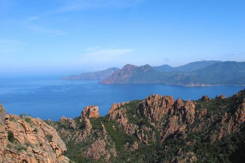 a view of a large body of water with mountains at Hôtel Mare E Monti in Piana