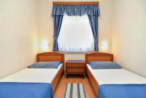2 łóżka w małym pokoju z oknem w obiekcie Apartments Vrcevan 811 w Medulinie