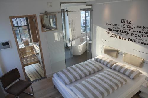 ビンツにあるBinzer Parkvillenのベッドルーム1室(ベッド1台付)、バスルーム(バスタブ付)が備わります。