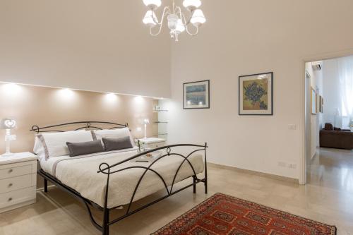 een witte slaapkamer met een bed en een kroonluchter bij Antica Residenza Adua in Verona