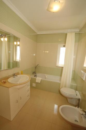 アルマカオ・デ・ペラにあるCasa Antonioのバスルーム(洗面台、トイレ、バスタブ付)