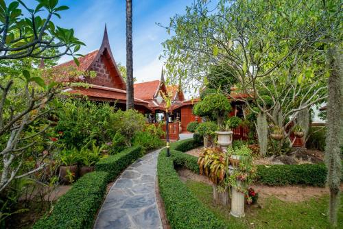 a garden in front of a house at Royal Thai Villa Phuket - SHA Extra Plus in Rawai Beach
