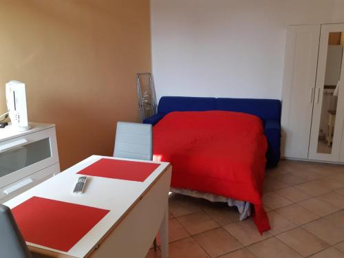 Zimmer mit einem Bett mit einer roten Decke in der Unterkunft Via Pioppa 24 in Ferrara