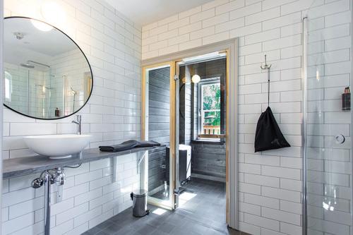 a white bathroom with a sink and a mirror at Lindesbergs Hotell in Lindesberg