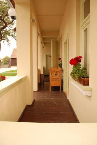 um corredor de uma casa com uma mesa e flores vermelhas em Borsika panzió em Ciumani