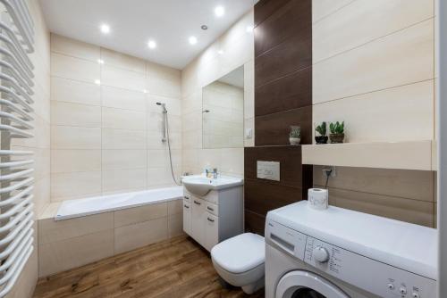 łazienka z umywalką, toaletą i wanną w obiekcie Waw - Apartamenty Wilanów I w Warszawie