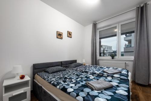a bedroom with a bed and a large window at Waw - Apartamenty Wilanów I in Warsaw