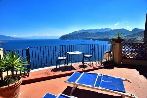 a balcony with a table and chairs and a view of the water at Hotel La Tonnarella in Sorrento