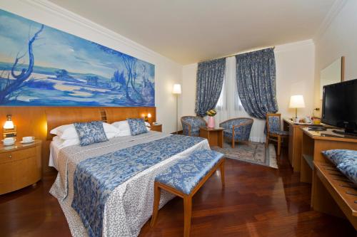 um quarto de hotel com uma cama e uma televisão em Villa Pace Park Hotel Bolognese em Preganziol