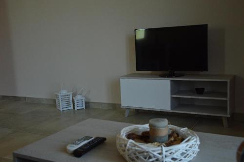 a living room with a tv and remote controls at Spiti Portokali in Ancient Epidauros