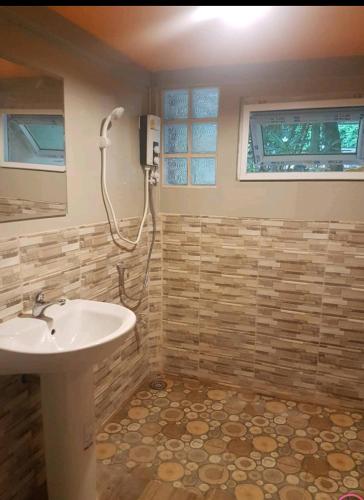 a bathroom with a sink and a shower at Kaengkrachan River Hut in Kaeng Krachan