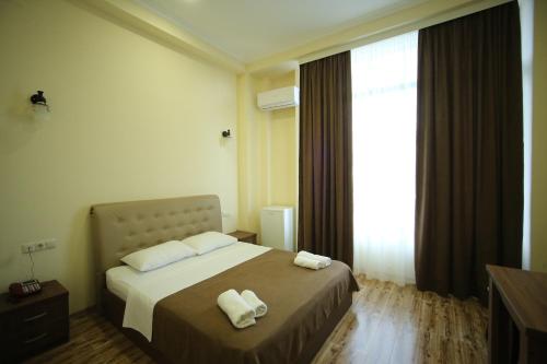 a bedroom with a bed with two towels on it at Hotel Comfort in Kutaisi
