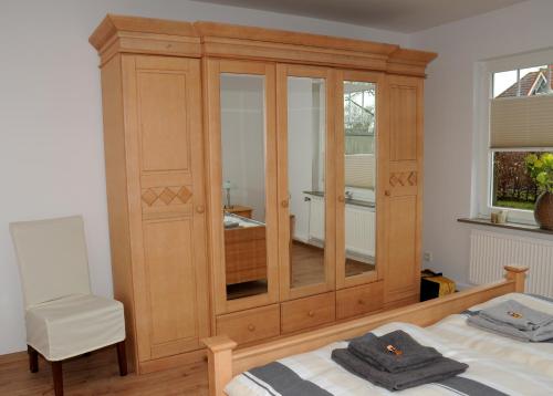a bedroom with a wooden cabinet and a bed at Ferienwohnung Landliebe in Leer
