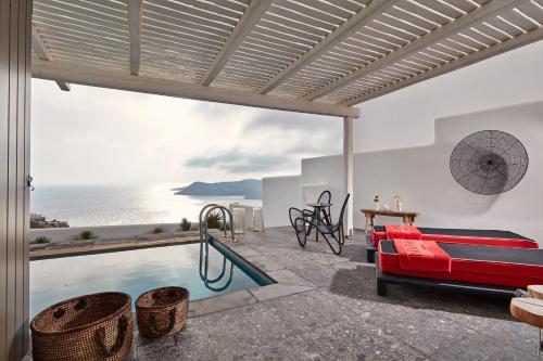 een villa met een zwembad en uitzicht op de oceaan bij Myconian Avaton, a Member of Design Hotels in Elia Beach