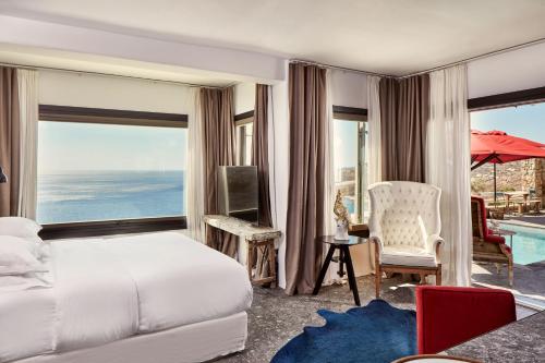 a bedroom with a bed and a view of the ocean at Myconian Avaton, a Member of Design Hotels in Elia Beach