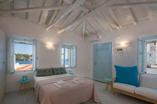 a bedroom with a bed and a couch and a window at moonhouse in Skiathos