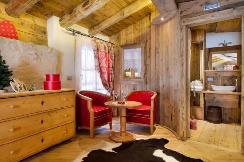 Pokój z czerwonymi krzesłami i stołem w pokoju w obiekcie Chalet Sogno di Fiaba w mieście Nembia