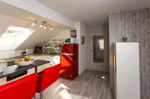 メトラッハにあるFerienwohnung Saarschleifeのキッチン(赤い冷蔵庫、赤い椅子付)