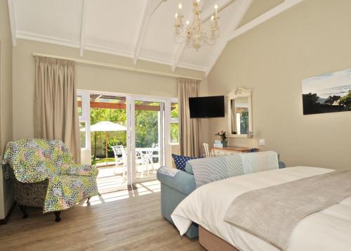 a bedroom with a bed and a living room at The Gables Hermanus in Hermanus