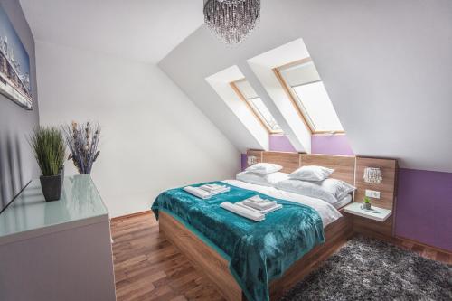- une chambre avec un lit et quelques lucarnes dans l'établissement Rubin Relax Apartman, à Sárvár