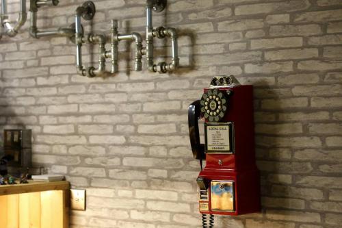 a red phone in a room with a brick wall at 蜂巢膠囊旅店 - Hive B&B in Hualien City