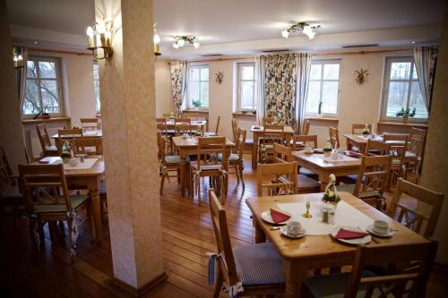 un restaurant vide avec des tables et des chaises en bois dans l'établissement Seehotel Huberhof, à Seehausen