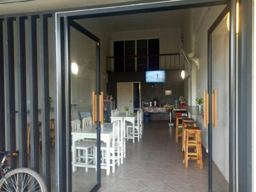 an open door to a dining room with tables and chairs at TT Hostel Chiangrai in Chiang Rai