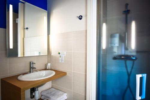 a bathroom with a shower, sink, and mirror at Cit'Hotel le Bord'O Vieux Port in La Rochelle