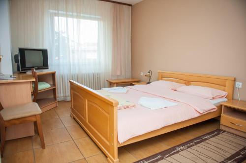 a bedroom with a large bed and a television at Prenoćište "NACIONAL" in Prnjavor