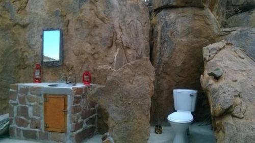 Baño de piedra con aseo y lavamanos en Madisa Camp, en Kalkbron