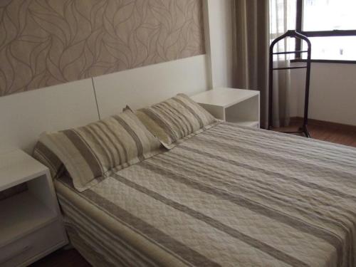 a bedroom with a large bed with two pillows at L'Hirondelle Flat Service in Campinas