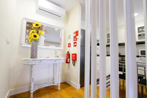 a room with a table with a vase of flowers on it at Casa do Tablado - Foz Côa in Vila Nova de Foz Coa