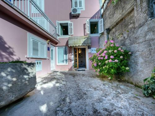 un bâtiment rose avec une plante aux fleurs roses dans l'établissement Lovely Mediterranean home near the beach, à Cavtat