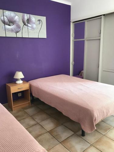duas camas num quarto com uma parede roxa em Villa La Marpierre em Mondragon