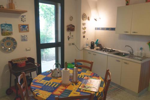cocina con mesa, fregadero, mesa y sillas en Donn'Anna B&B, en Squinzano