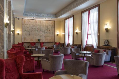 a waiting room with tables and chairs and a map at Bettoja Hotel Mediterraneo in Rome