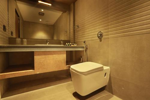 a bathroom with a white toilet and a sink at Aura One Hotel in Cochin