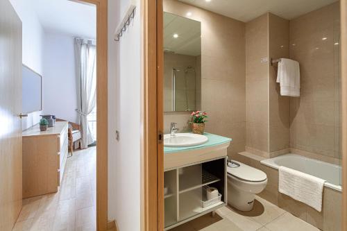 a bathroom with a sink and a toilet and a tub at Habitat Apartments Alibei in Barcelona