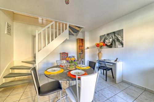 une salle à manger avec une table et des chaises et un escalier dans l'établissement Gîte La Vapillone Paris Marne-la-Vallée, à Serris