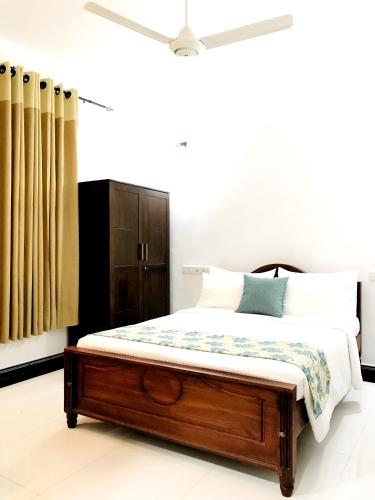 a bedroom with a bed with a wooden bed frame at Siluni's Villa in Anuradhapura