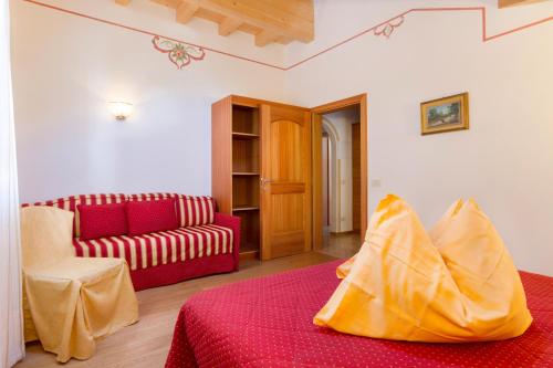 ein Wohnzimmer mit einem Sofa und einem roten Bett in der Unterkunft Casa Nonni in Molveno