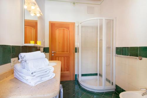 bagno con doccia e un mucchio di asciugamani di Casa Nonni a Molveno