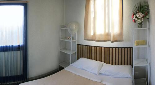 a bedroom with a bed and a window and shelves at Camping Villaggio Lamaforca in Torre Santa Sabina