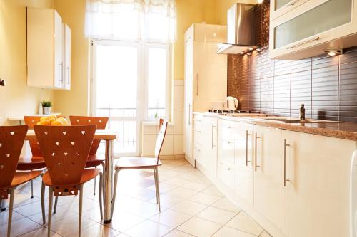 eine Küche mit einem Tisch und Stühlen sowie eine Küche mit weißen Schränken in der Unterkunft 3 bedroom apartment Kołłątaja Street in Krakau