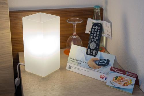 a remote control on a table next to a light at Hotel & Apartment Am Theaterplatz in Bremerhaven