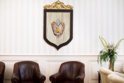two leather chairs in a room with a picture on the wall at Hotel Palazzo Guardati in Sorrento