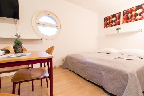 1 dormitorio con cama, mesa y escritorio en Apartmenthaus Hietzing I contactless check-in, en Viena