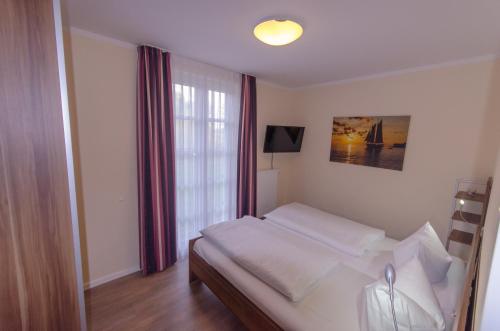 1 dormitorio con cama y ventana en Ferienwohnung 39 Residenz Balmer See, en Balm