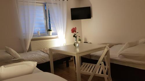 a living room with a table and a bed at Pokoje gościnne Venezia in Czaplinek